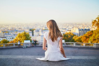 Güzel genç bir kadın Paris, Fransa manzarasının tadını çıkarıyor. Montmartre tepesinde beyaz elbiseli bir kız.
