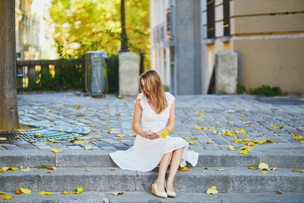 美しい白いドレスの若い女性が黄色の秋の葉で階段に座っている有名なモンマルトルの丘の上にパリ フランスの早朝 — ストック写真