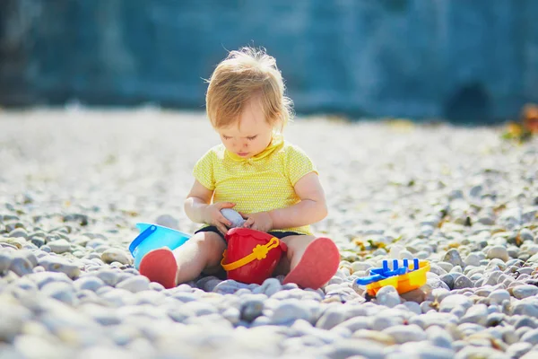 ビーチで小石で遊んでいる愛らしい幼児の女の子 フランスのノルマンディー エチケットの海の近くで楽しい時間を過ごしている小さな子供 子供のための屋外活動 — ストック写真
