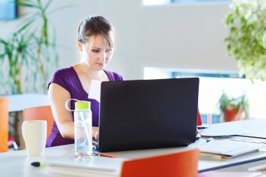 Dizüstü bilgisayarı, kitapları ve kağıtları olan bir öğrenci, evde çalışıyor. Koronavirüs salgını sırasında karantina ve kapalı okullar ve ofisler. Evde eğitim, uzak öğrenim ve serbest meslek