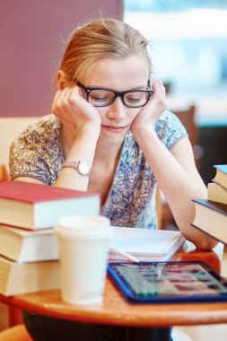 Tabletli, kitaplı ve kağıtlı bir öğrenci, evde çalışıyor. Koronavirüs salgını sırasında karantina ve kapalı okullar ve ofisler. Evde eğitim, uzak öğrenim ve serbest meslek