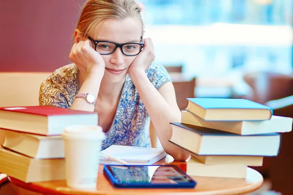 Student with tablet, books and papers, studying at home. Quarantine and closed schools and offices during coronavirus outbreak. Homeschooling, distance learning and freelance job