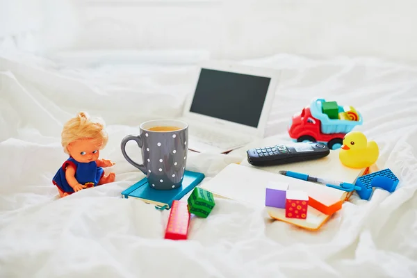 笔记本电脑 一杯咖啡 笔记本 手机和不同的玩具躺在干净的白布床上 自由学习 远距离学习或在家带孩子工作的概念 — 图库照片