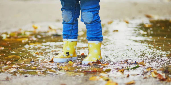 Παιδί Που Φοράει Κίτρινες Μπότες Βροχής Και Πηδάει Στη Λακκούβα — Φωτογραφία Αρχείου