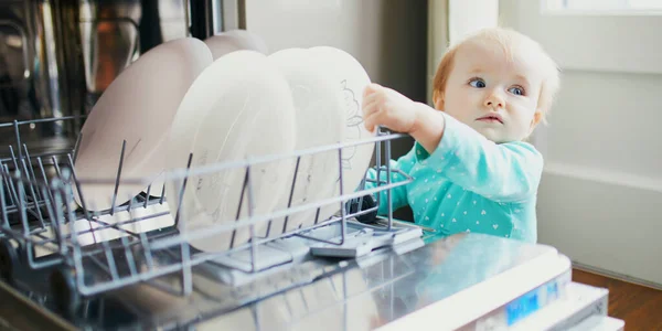 Criança Ajudando Descarregar Máquina Lavar Louça Menina Sentada Chão Cozinha — Fotografia de Stock