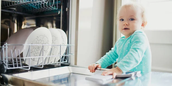 Criança Ajudando Descarregar Máquina Lavar Louça Menina Sentada Chão Cozinha — Fotografia de Stock