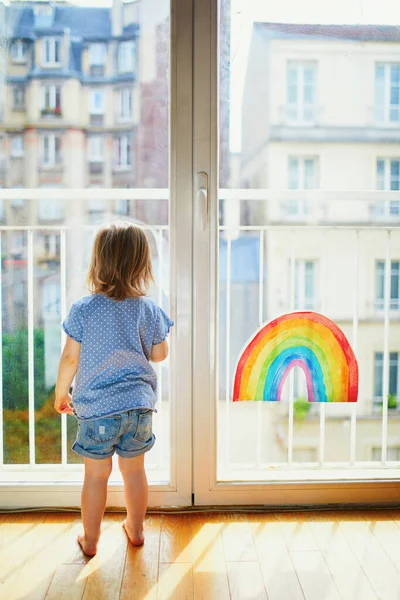Förtjusande Liten Flicka Som Tittar Genom Fönstret Med Regnbågsritning Kreativa — Stockfoto