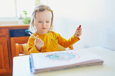 Evde renkli akvaryum resimleriyle Coronavirus çizen sevimli küçük kız. Çocuklar için yaratıcı oyunlar, eğitim ve uzak mesafe eğitimi. Evde kalıp eğlenin.