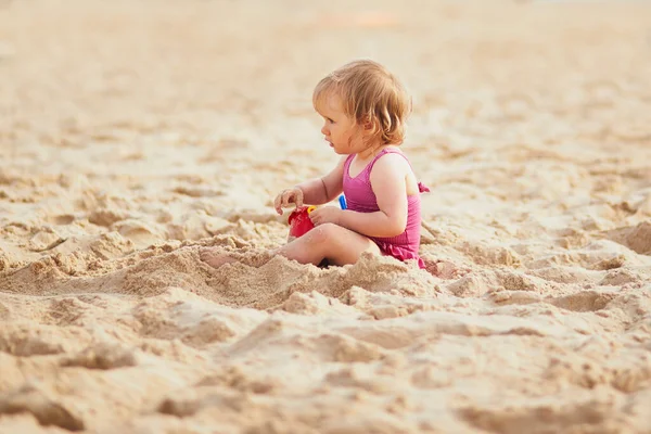 Premium Photo  Baby girl on a sandy beach near the river holds a
