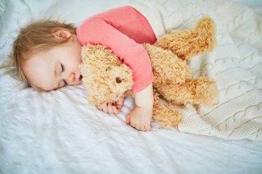 En sevdiği oyuncakla yatan sevimli kız bebek. Küçük çocuk bir gün şekerleme yapıyor ve oyuncak ayıya sarılıyor. Kreşte dinlenen bebek çocuk