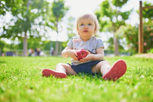 Adorable Little Girl Eating Red Apple Outdoors Park Sunny Day — Stock Photo, Image