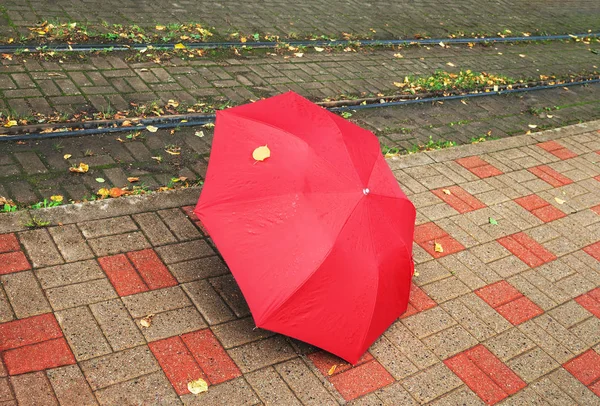 Ombrello rosso su una strada . — Foto Stock