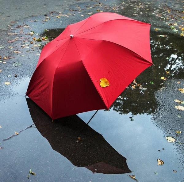 Ombrello rosso su una strada . — Foto Stock