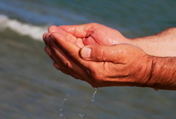 Mãos com água do mar . — Fotografia de Stock