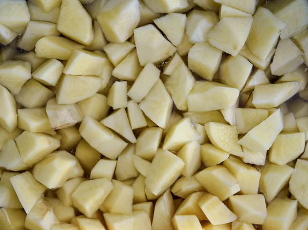 Batatas cortadas em pedaços na água . — Fotografia de Stock