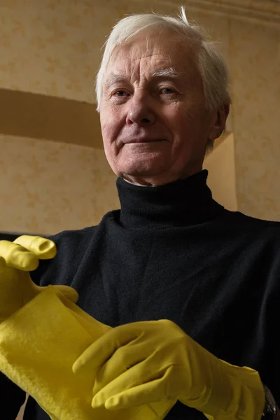Old man in rubber gloves. — Stock Photo, Image