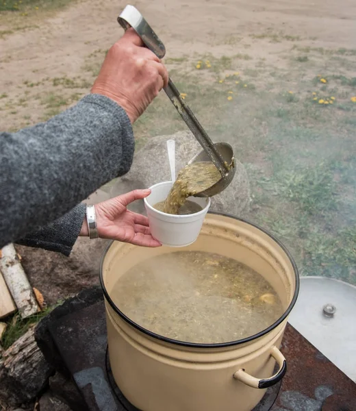 Frau gießt Suppe in einen Teller. — Stockfoto