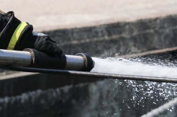 Bombeiro pulverizando água . — Fotografia de Stock