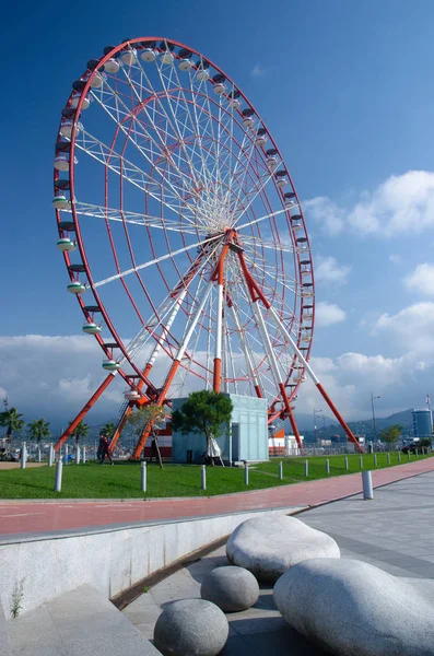 Rueda de la fortuna en la playa de Batumi en el día soleado con hermosos bancos en forma de piedra, Georgia, Adzharia — Foto de Stock