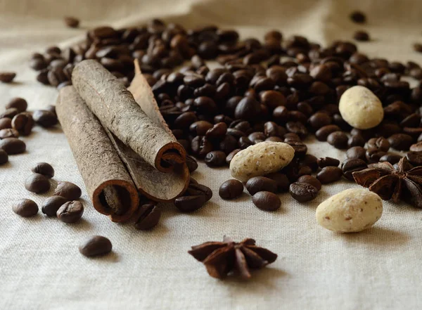 Zimtstangen, Kaffeebohnen, Anis und weiße Schokolade Mandelbonbons Stillleben, Lebensmittel Hintergrund — Stockfoto