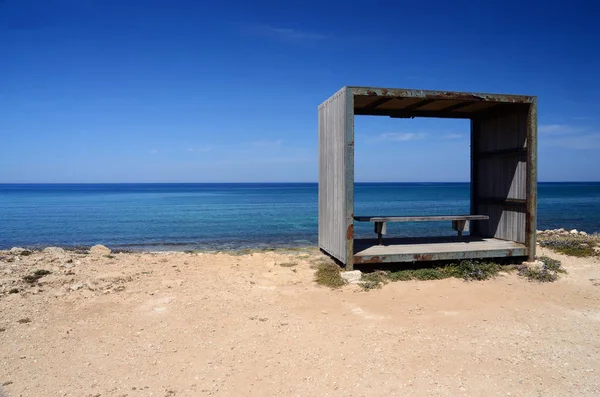 Скамейка внутри деревянной рамы, место отдыха на побережье Кипра, Като-Пахос на берегу моря — стоковое фото