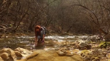 Bir yürüyüş sırasında akıştan elleri temiz saf su içme kadın uzun yürüyüşe çıkan kimse