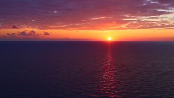 Coucher de soleil sur la mer. Le soleil et le ciel orange se reflètent dans le surf. Tir au ralenti. 4K, UHD 