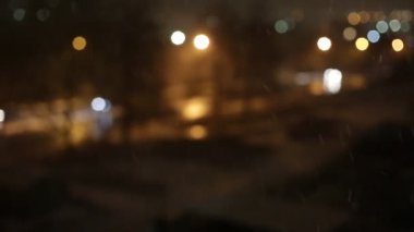 Yağmurlu günler, yağmur damlaları pencere yüzey ve renkli bokeh ampul üzerinde.