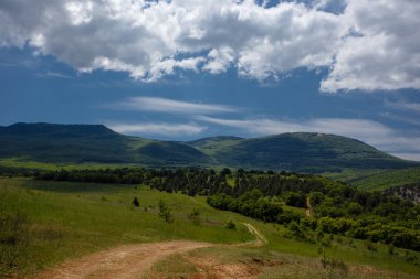 Yaz alan yol ve mavi gökyüzünde bulutlar ile.