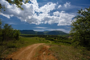 Yaz alan yol ve mavi gökyüzünde bulutlar ile.