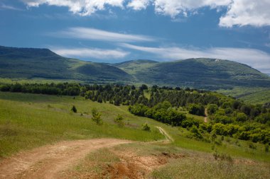Yaz alan yol ve mavi gökyüzünde bulutlar ile.