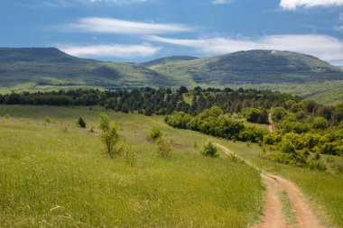 Yaz alan yol ve mavi gökyüzünde bulutlar ile.