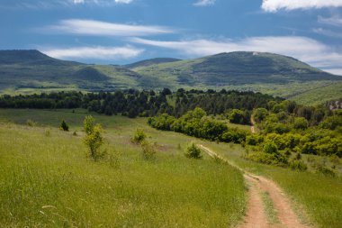 Yaz alan yol ve mavi gökyüzünde bulutlar ile.