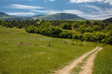 Yaz alan yol ve mavi gökyüzünde bulutlar ile.