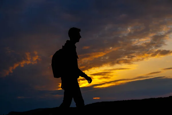 Silhouetten von Wanderern mit Rucksack genießen Sonnenuntergang Blick von der Spitze eines Berges — Stockfoto