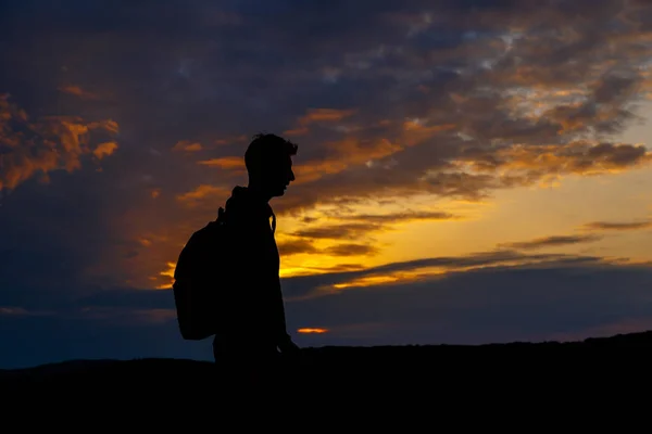 Silhouetten von Wanderern mit Rucksack genießen Sonnenuntergang Blick von der Spitze eines Berges — Stockfoto