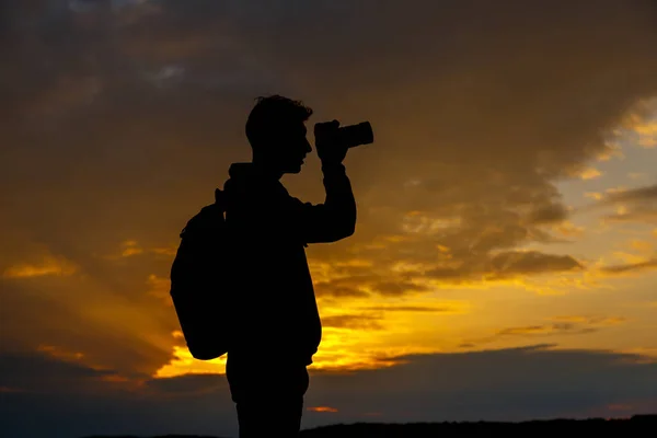 Silhouette eines Fotografen, der Landschaft bei Sonnenuntergang fotografiert — Stockfoto