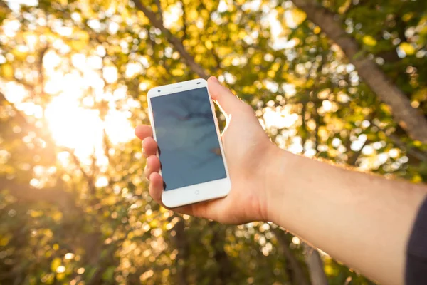 Primer plano de un hombre que utiliza el teléfono inteligente móvil al aire libre — Foto de Stock