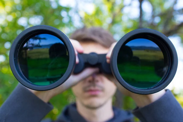 Jovem homem uso do binocular na floresta — Fotografia de Stock