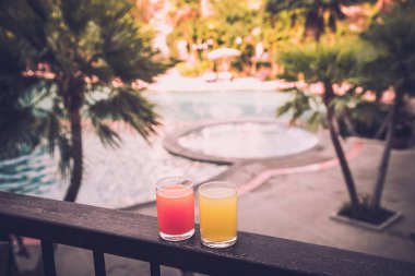 Bir yüzme havuzu etrafında portakal suyu