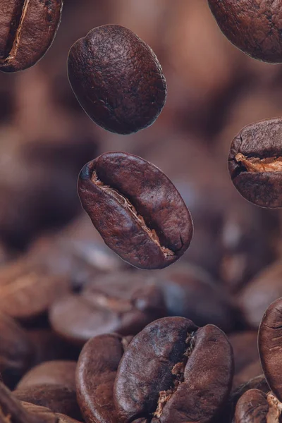 Primer plano de granos de café en el café tostado. Grano de café sobre fondo de café macro molido. Café tostado árabe - ingrediente de la bebida caliente . —  Fotos de Stock