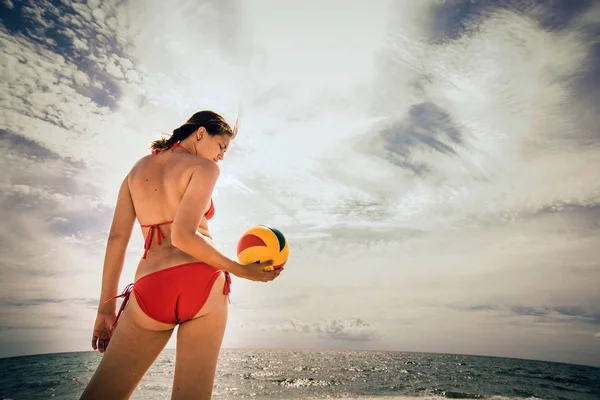 Υγιή γυναίκα γέλιο με μπάλα παραλία ενώ στην παραλία το καλοκαίρι — Φωτογραφία Αρχείου