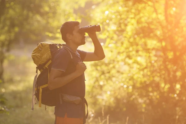 Jovem Viajante com mochila relaxante ao ar livre com floresta em segundo plano férias de verão e conceito de estilo de vida — Fotografia de Stock