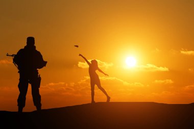 bir silah ve bir kağıt uçak ile oynayan küçük bir kız bir adam silüeti