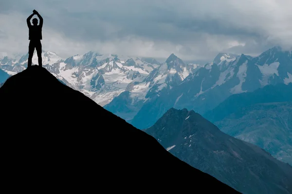 Hombre contra el mar de pie en una cima de la montaña mirando a la distancia — Foto de Stock