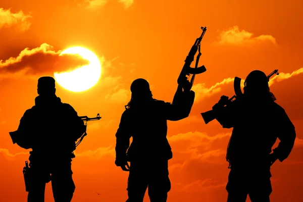 Drie militaire soldaten afsteekt tegen een prachtige zonsondergang — Stockfoto