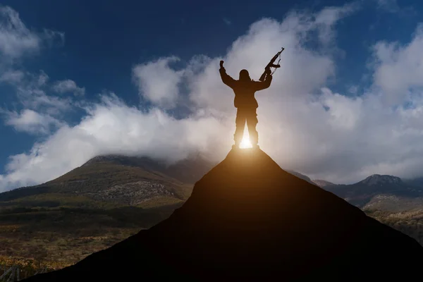 Muž proti moři stojí na vrcholu hory a dívá se do dálky — Stock fotografie