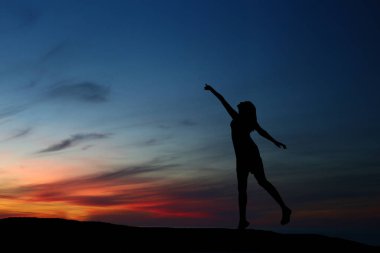 güzel bir gün batımı arka plan üzerinde dans siluet kız