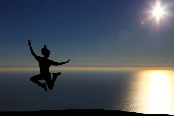 Krásná silueta dívka, která skočila při západu slunce — Stock fotografie