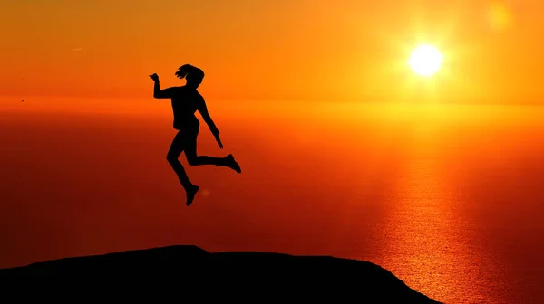 Beautiful silhouette of a girl jumping at sunset — Stock Photo, Image